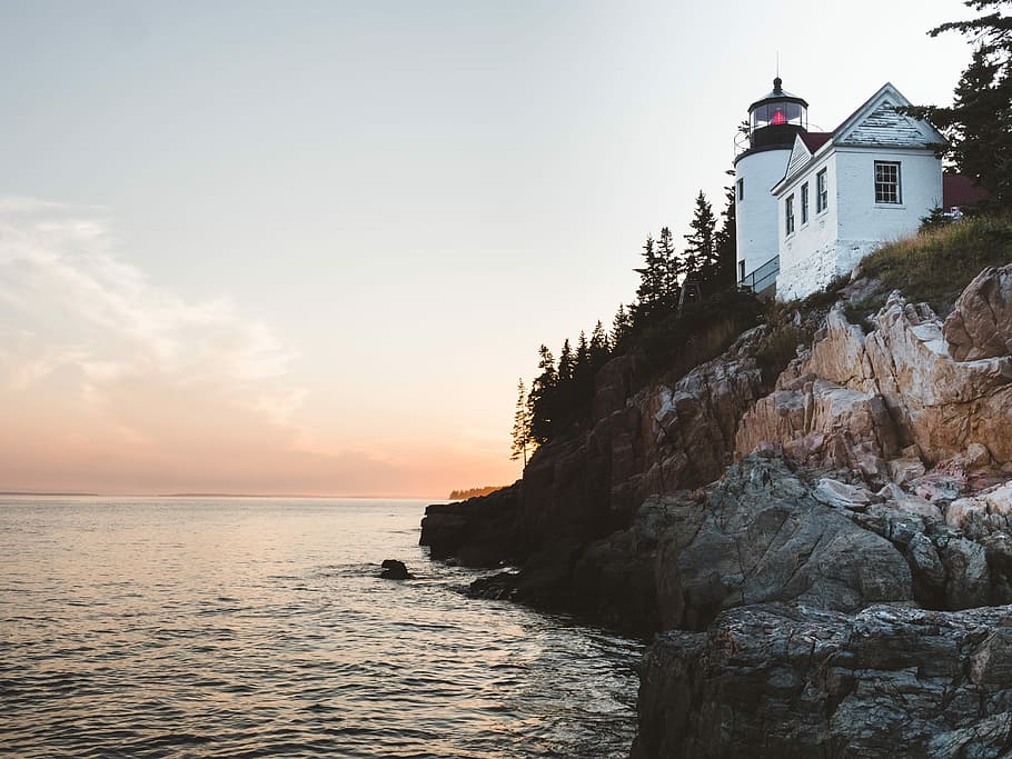 white lighthouse near sea at daytime, white house on cliff beside sea HD wallpaper