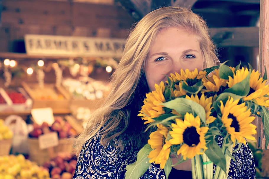 woman in blue and white floral top holding sunflower buoquet, woman holding sunflower bouquet HD wallpaper