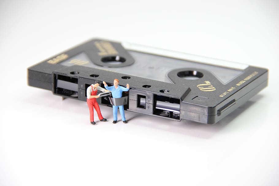 black cassette tape with man figurine, caught, miniature figures