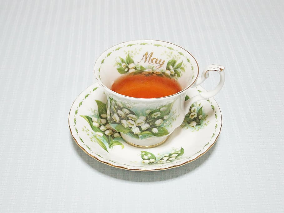 white and green floral teacup filled with brown liquid on saucer HD wallpaper