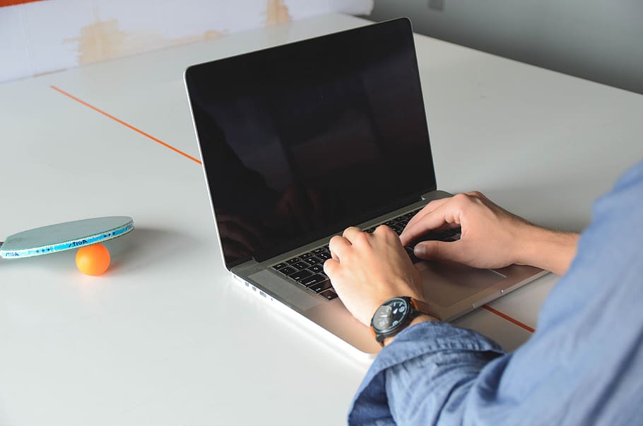 person wearing blue dress shirt using MacBook Pro, startup HD wallpaper