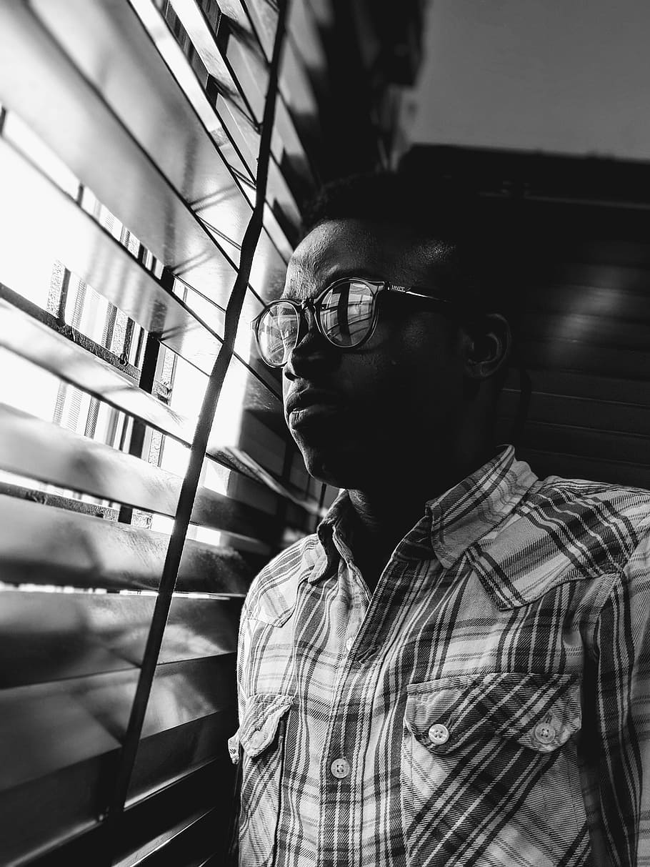 Grayscale photo of man standing near window photo – Free Cloud