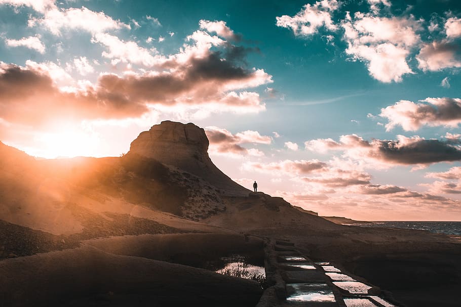 silhouette photography of person standing near mountain, landscape photography of mountain during golden hour HD wallpaper