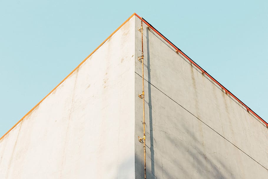 low angle photography of brown pipe near building, low angle photography of gray concrete building HD wallpaper