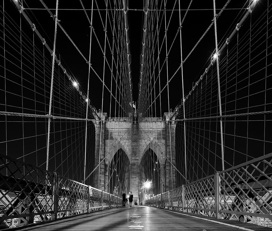 person walking on bridge in grayscale photography, brooklyn bridge