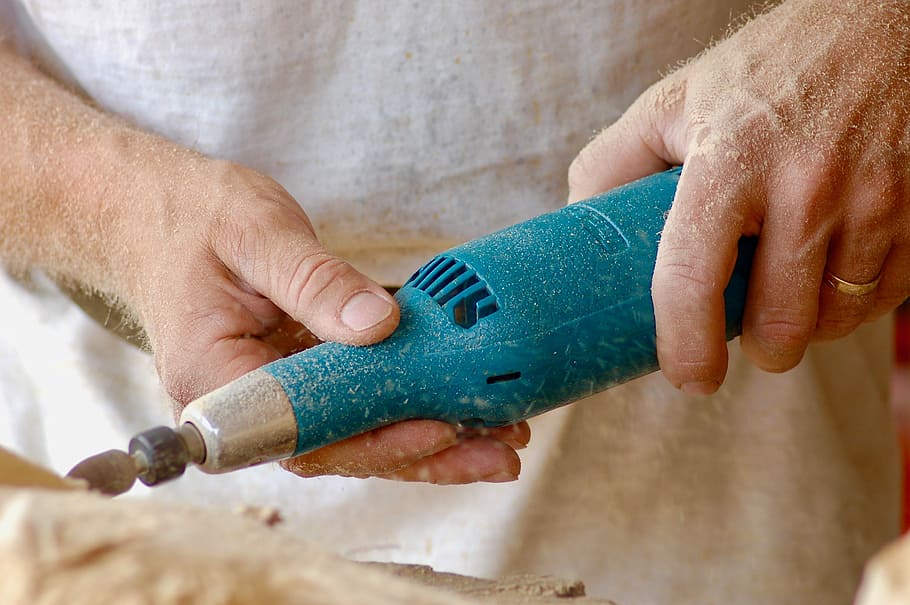 person holding blue power tool, person holding brown rotary tool closeup photography HD wallpaper