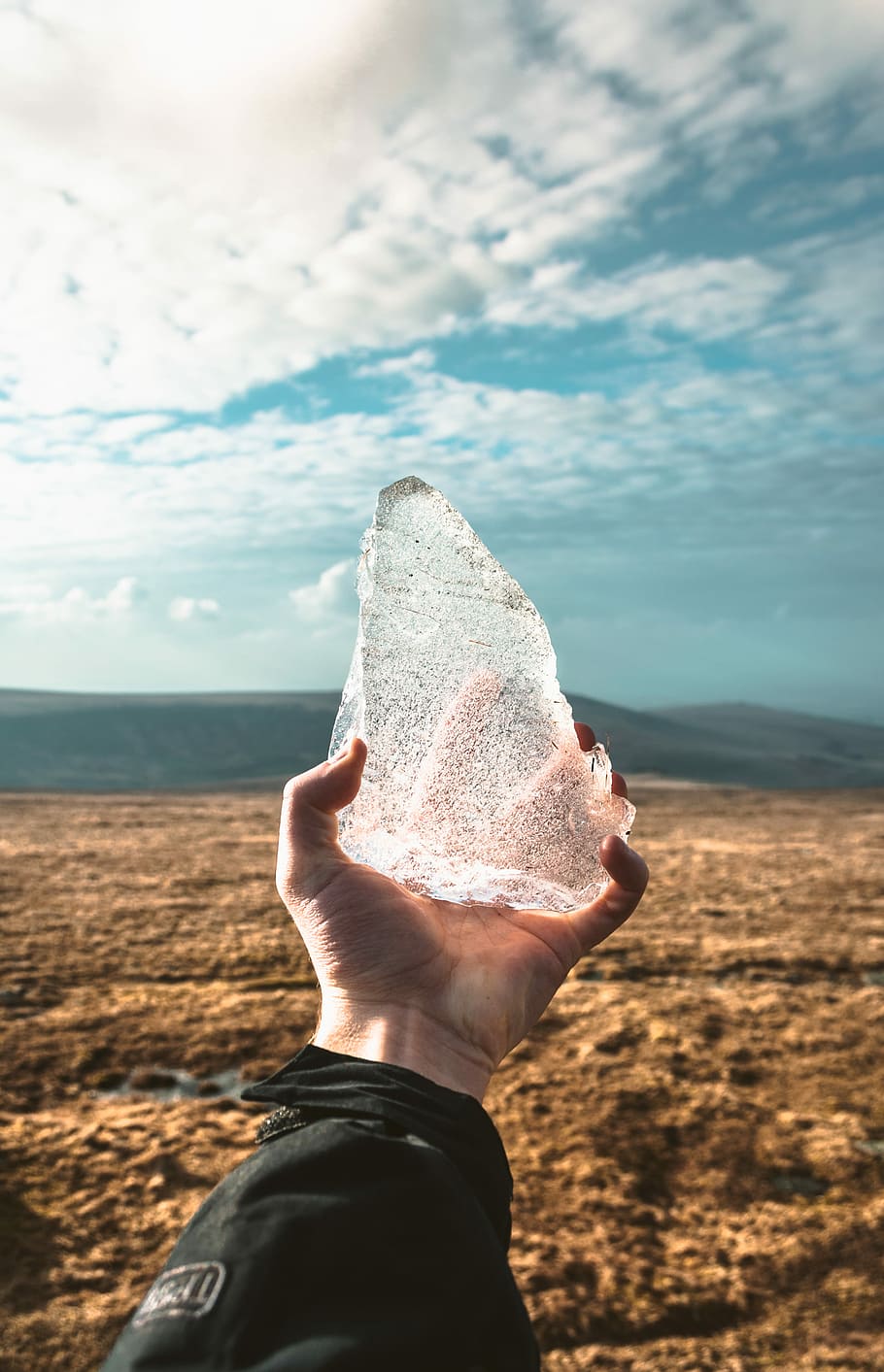 person holding ice during day time, selective focus photo of person holding clear stone HD wallpaper