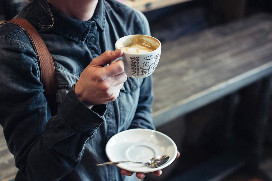 person holding cup of coffee and saucer, woman holding cup of latte and saucer HD wallpaper