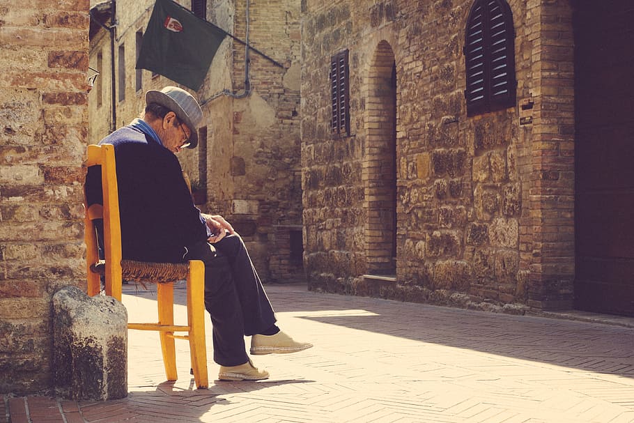 man sitting on yellow chair while looking downwards, old, fedora HD wallpaper
