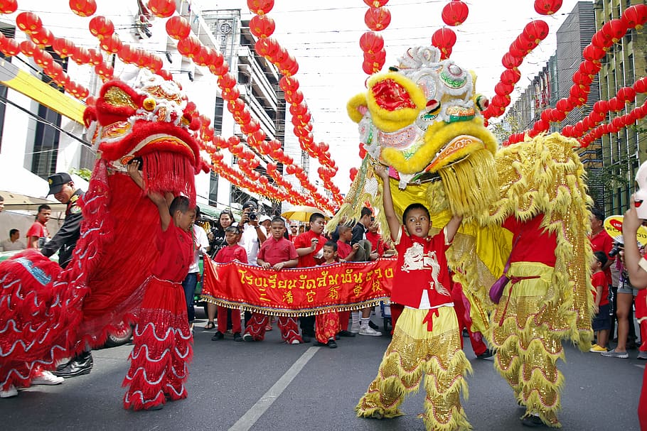 group of person performing dragon dance on street, the lion dance