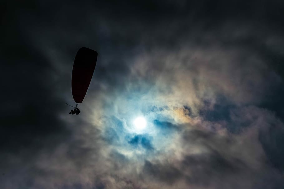 low angle photo of silhouette of man with parachute, aerial photography of person paragliding HD wallpaper