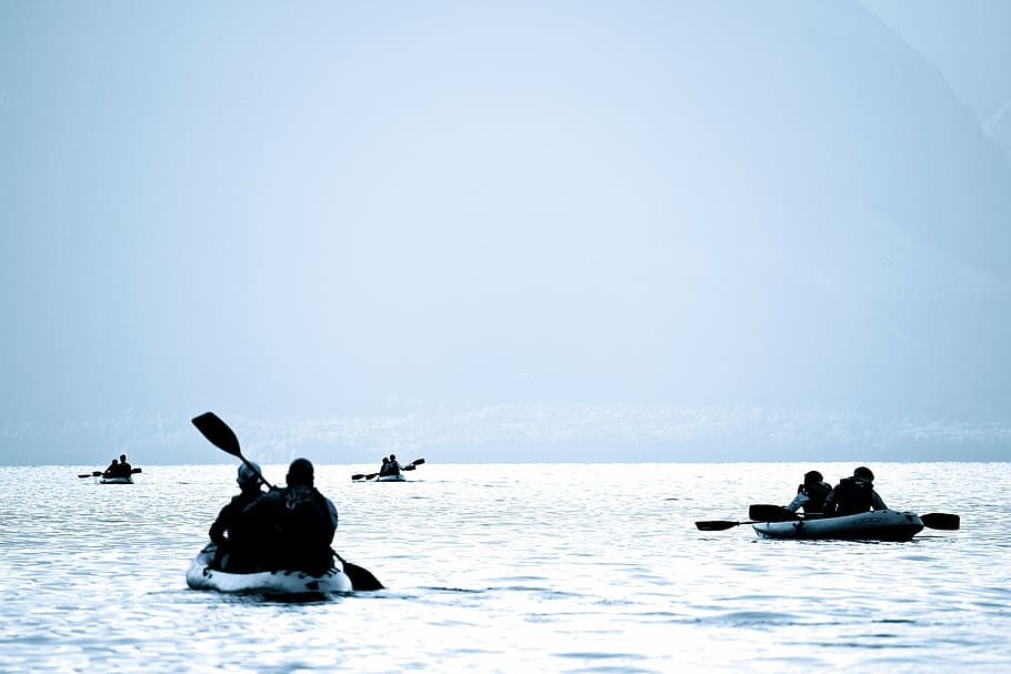 four people riding boat paddling on sea during daytime, eight
