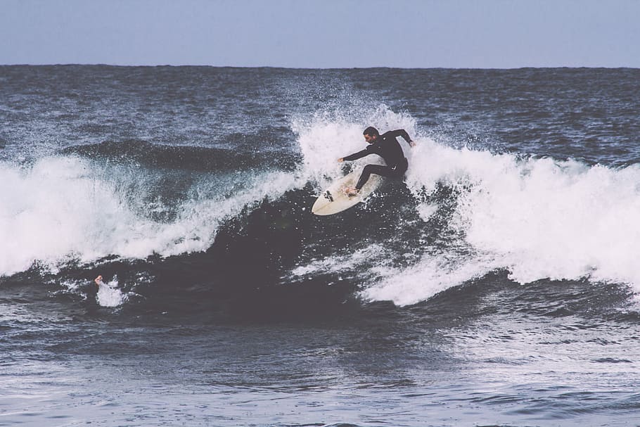 man surfboarding during daytime, man surfboarding on ocean wave HD wallpaper