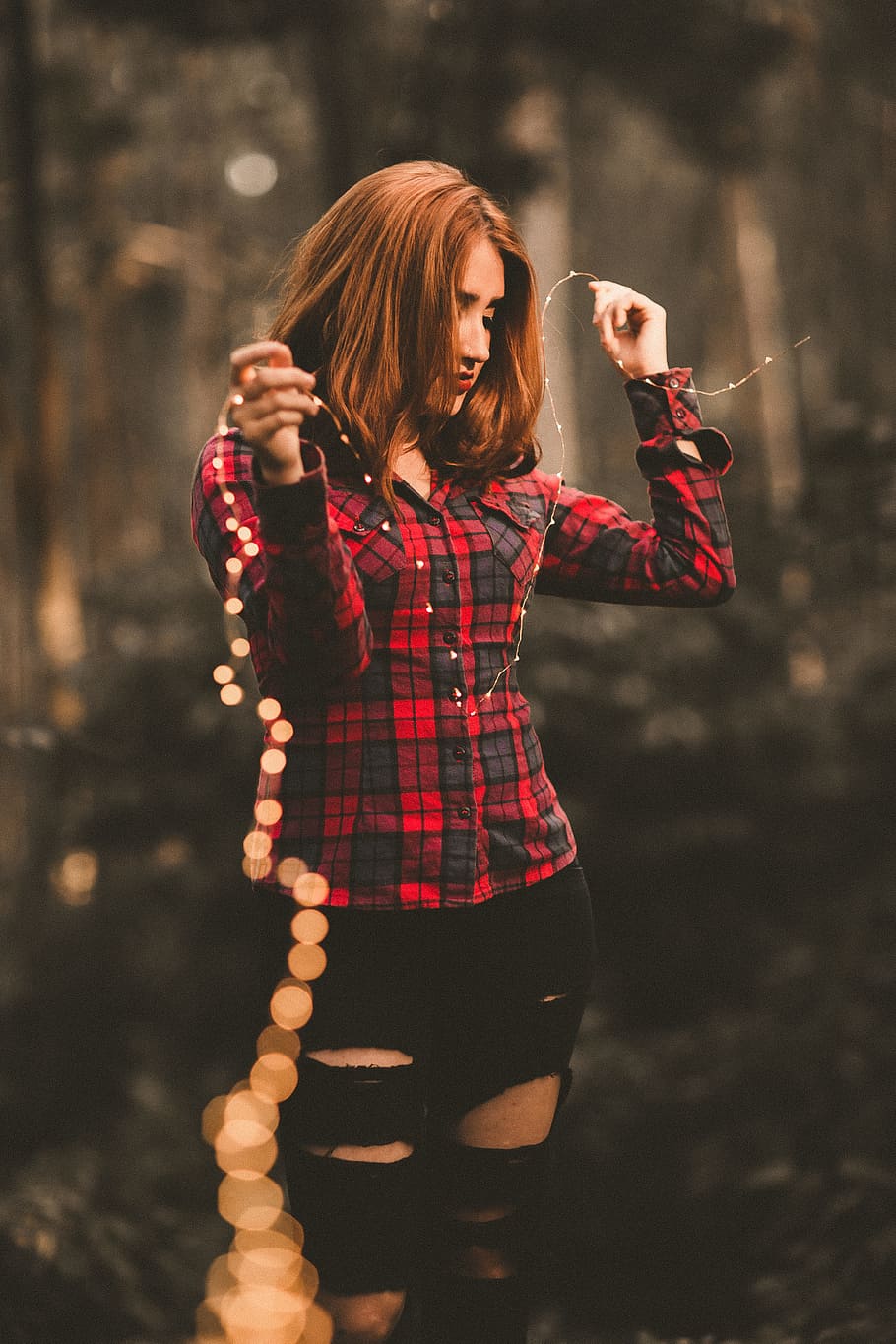 woman in red and black dress shirt, selective focus photography of woman holding a strip lights HD wallpaper