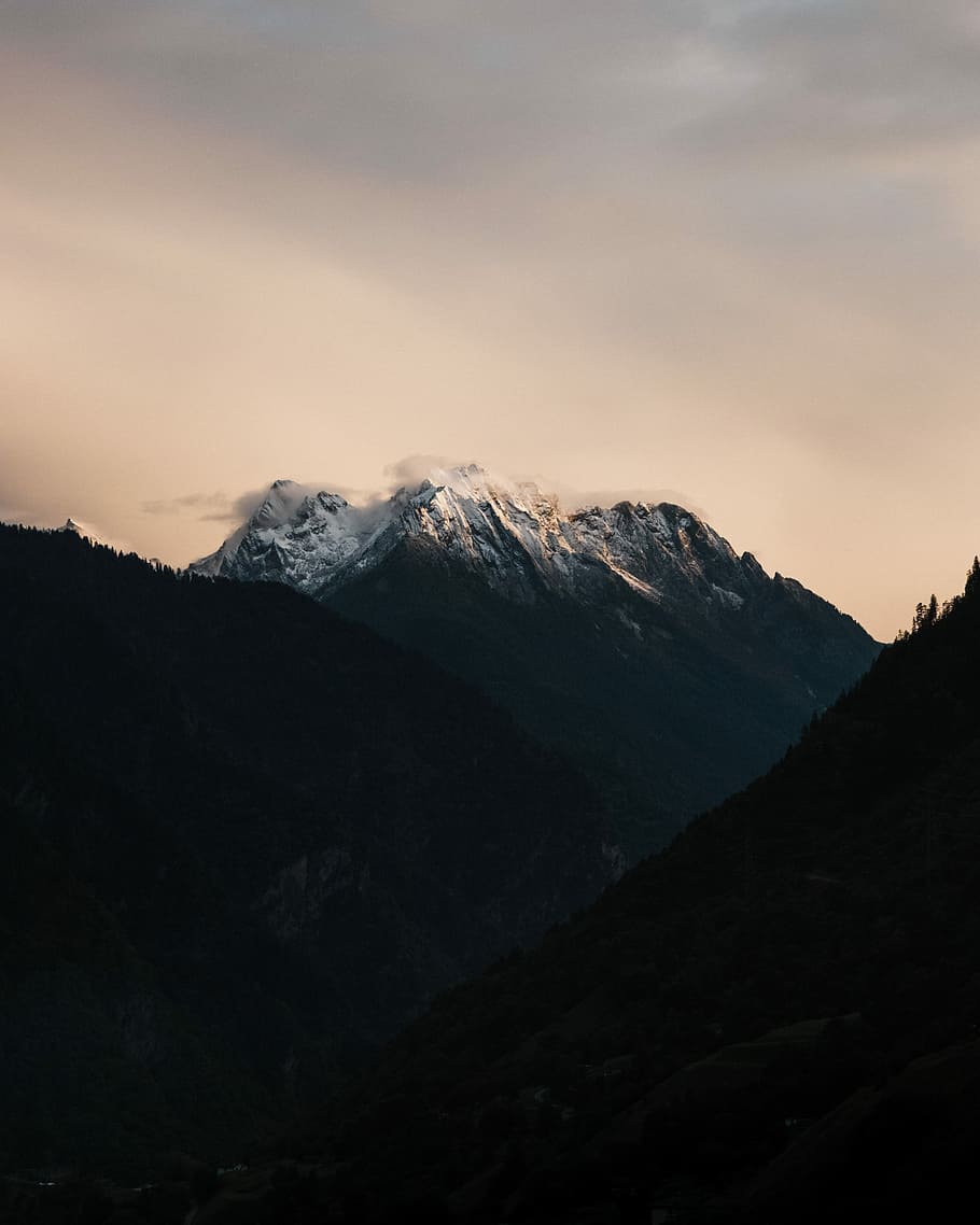 white and black mountain under gray sky, mountain under cloudy sky during daytime HD wallpaper