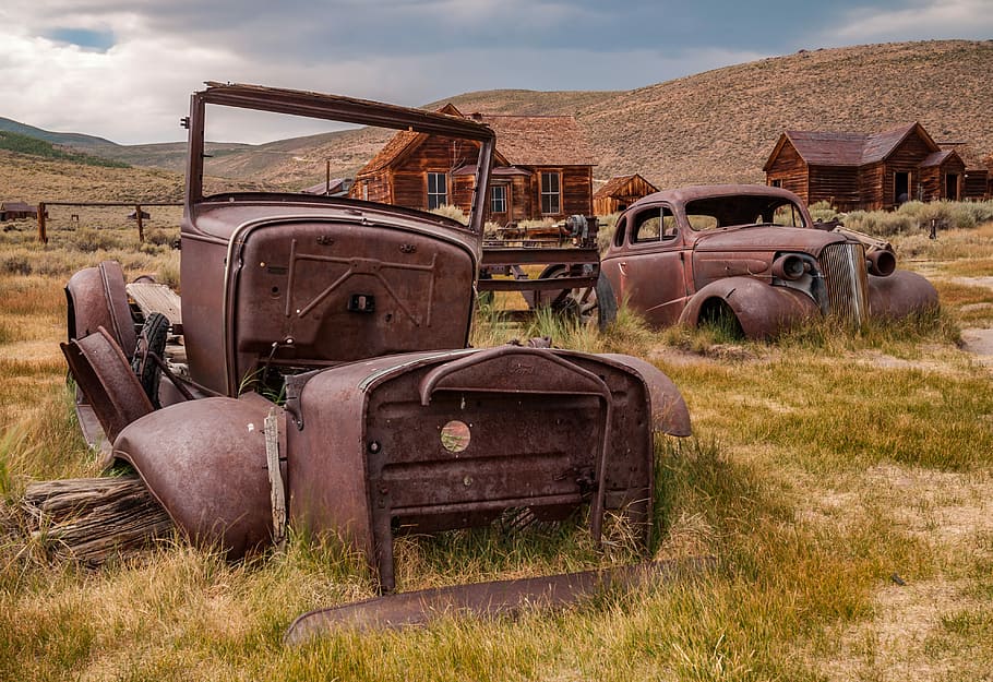 brown metal vehicles, abandoned vehicles near brown house at daytime HD wallpaper