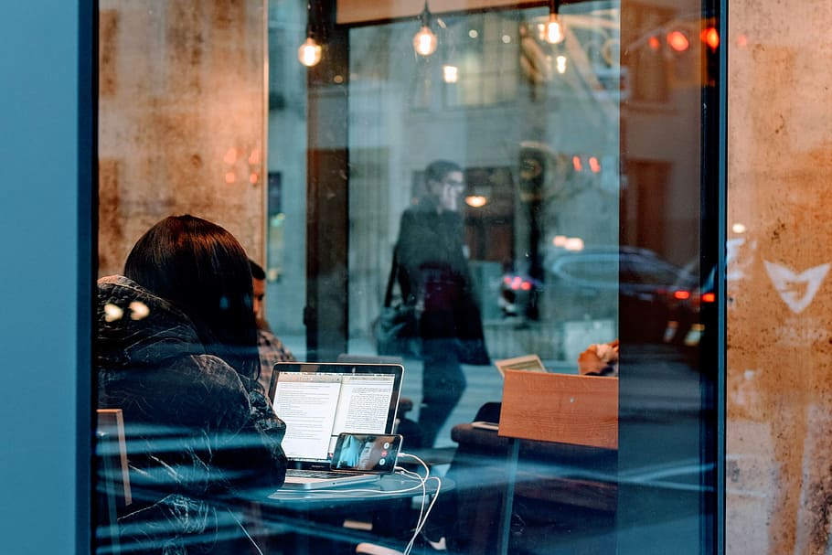 woman inside a building using her laptop, woman sitting in front of turned on laptop HD wallpaper