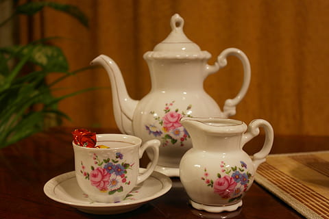 three white-and-pink floral ceramic tea set on brown wooden surface HD wallpaper