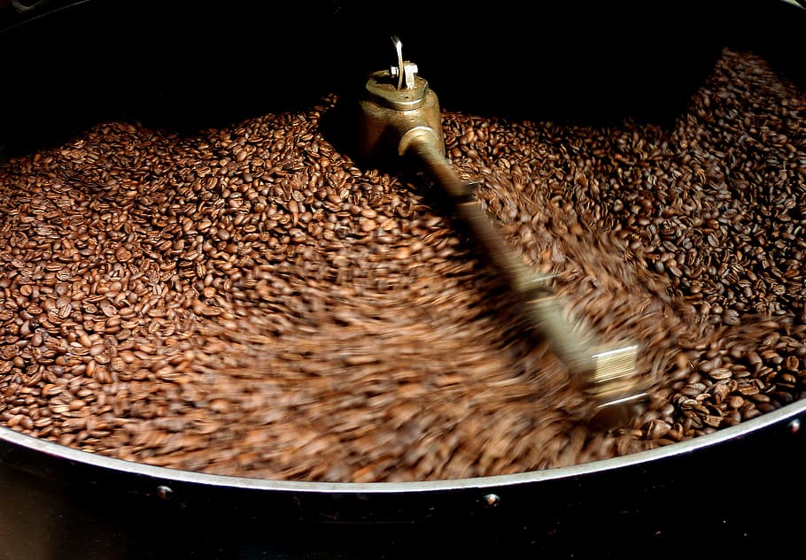 stainless steel and brown coffee bean mill filled with coffee beans