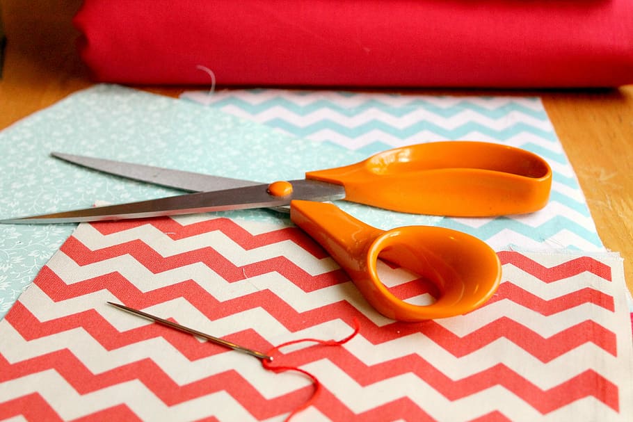 orange scissors on red and white paper, sewing, fabric, thread