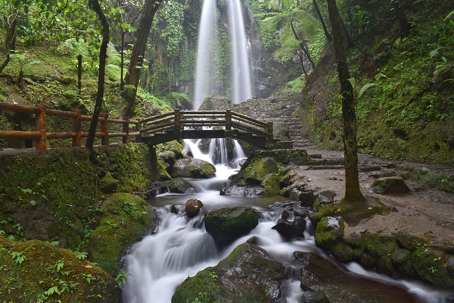 time lapse photography of water flowing on the rocks with bridge HD wallpaper