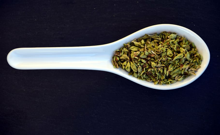 green spice on white cermic spoon, oregano, close, aromatic, fragrant