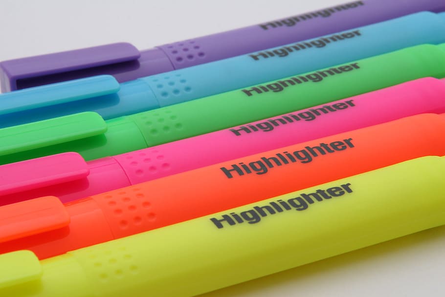 six assorted Highlighter pens on top of white surface, artistic