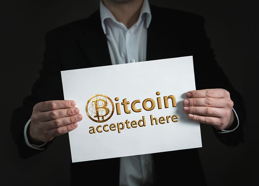 man holding Bitcoin accepted here signage, crypto-currency, money