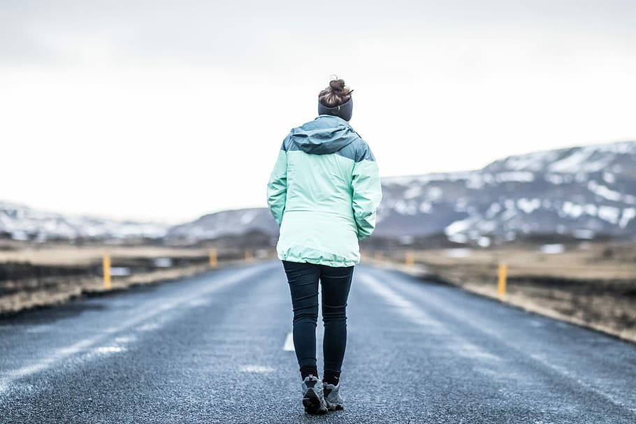 woman wearing teal jacket and black pants walking on concrete road, person wearing teal jacket while walking on road during daytime, HD wallpaper