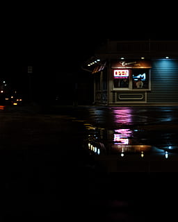 A store in the dark and a puddle reflecting the neon lights from the storefront window, turned on open neon signage HD wallpaper