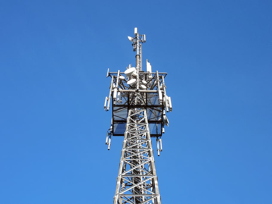 low-angle photography of gray tower under blue sky, transmission tower