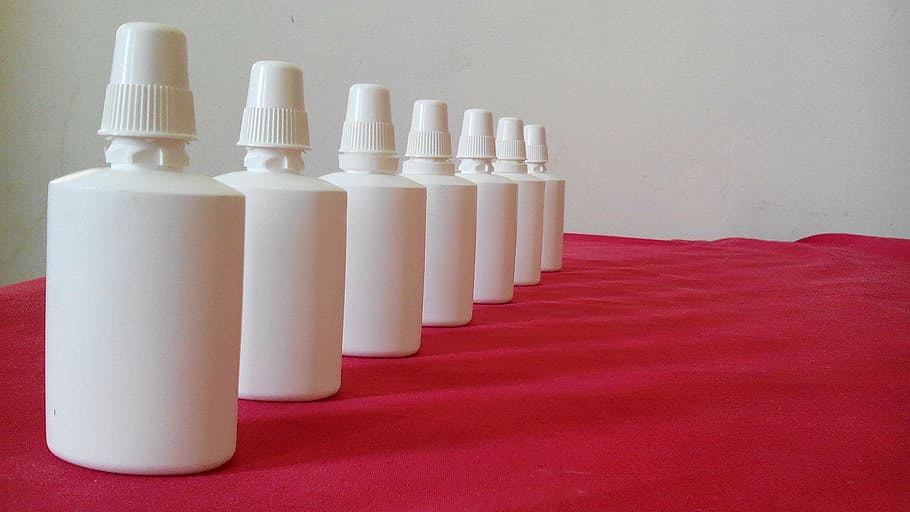 several white plastic bottles on red cloth, collection, spray