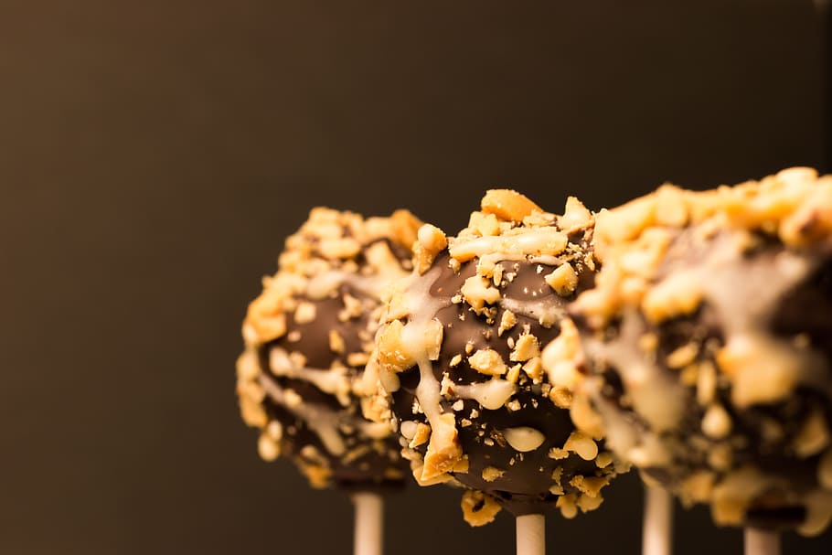 close-up photography of three chocolate lollipops with peanuts HD wallpaper