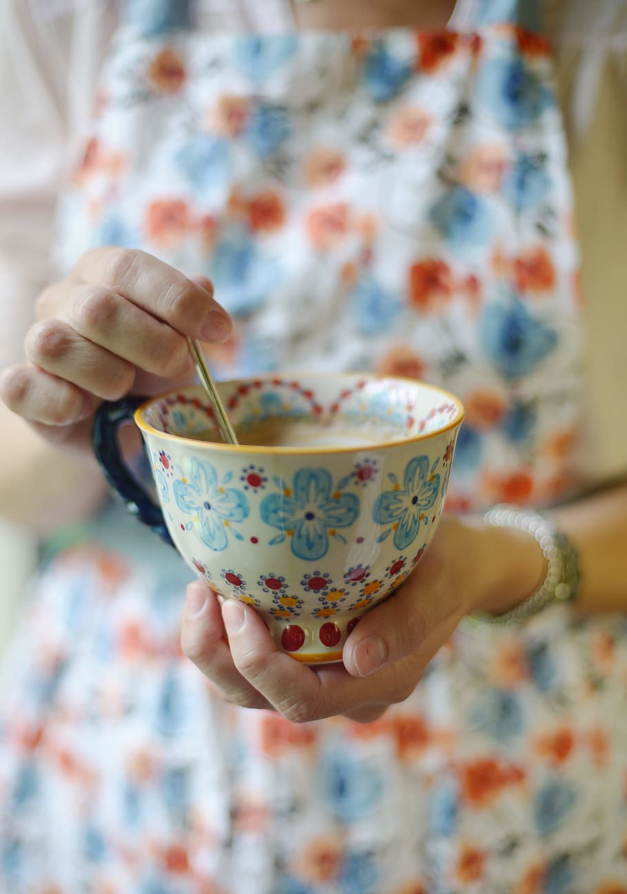 person holding multicolored ceramic teacup, person stirring cup HD wallpaper