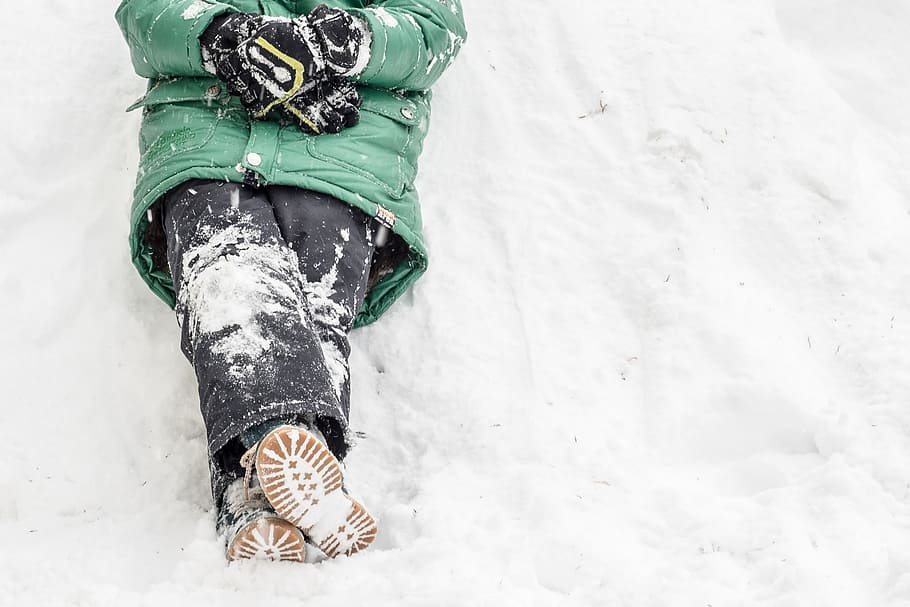 person wearing green windbreaker bubble jacket and black jeans sitting on snow at daytime, HD wallpaper