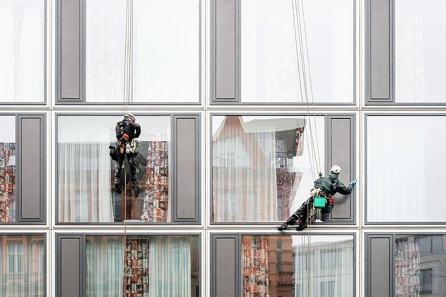 man hanging beside building window, two men wiping high-rise building glass windows HD wallpaper