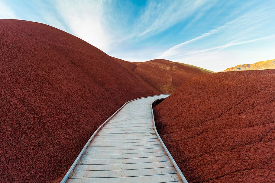 stairway between mountain, brown wooden pathway in the middle of red hills under blue skies HD wallpaper