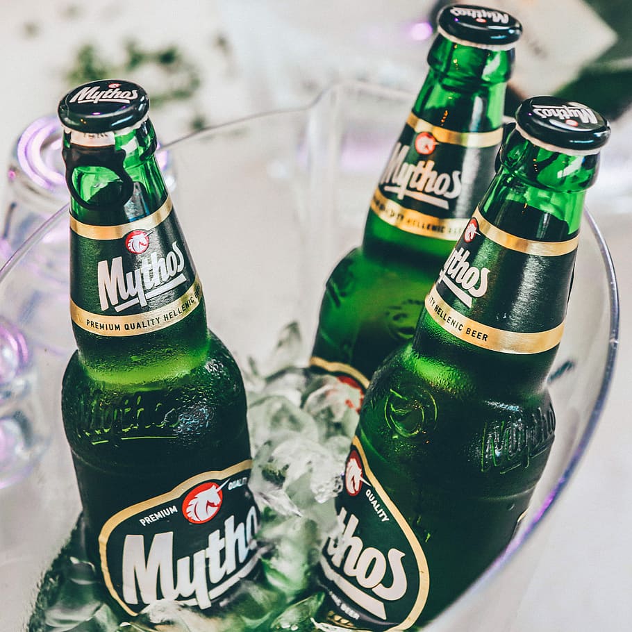 three green beer glass bottles, three Mythos beer bottles in ice bucket HD wallpaper