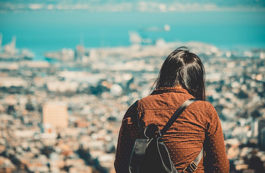 shallow focus photography of woman in brown collared top during daytime, person looking at city from bird's eye view close-up photography HD wallpaper