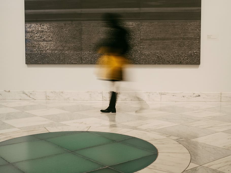timelapse photography of person walking beside 3-panel painting, person standing on floor tiles in building interior HD wallpaper
