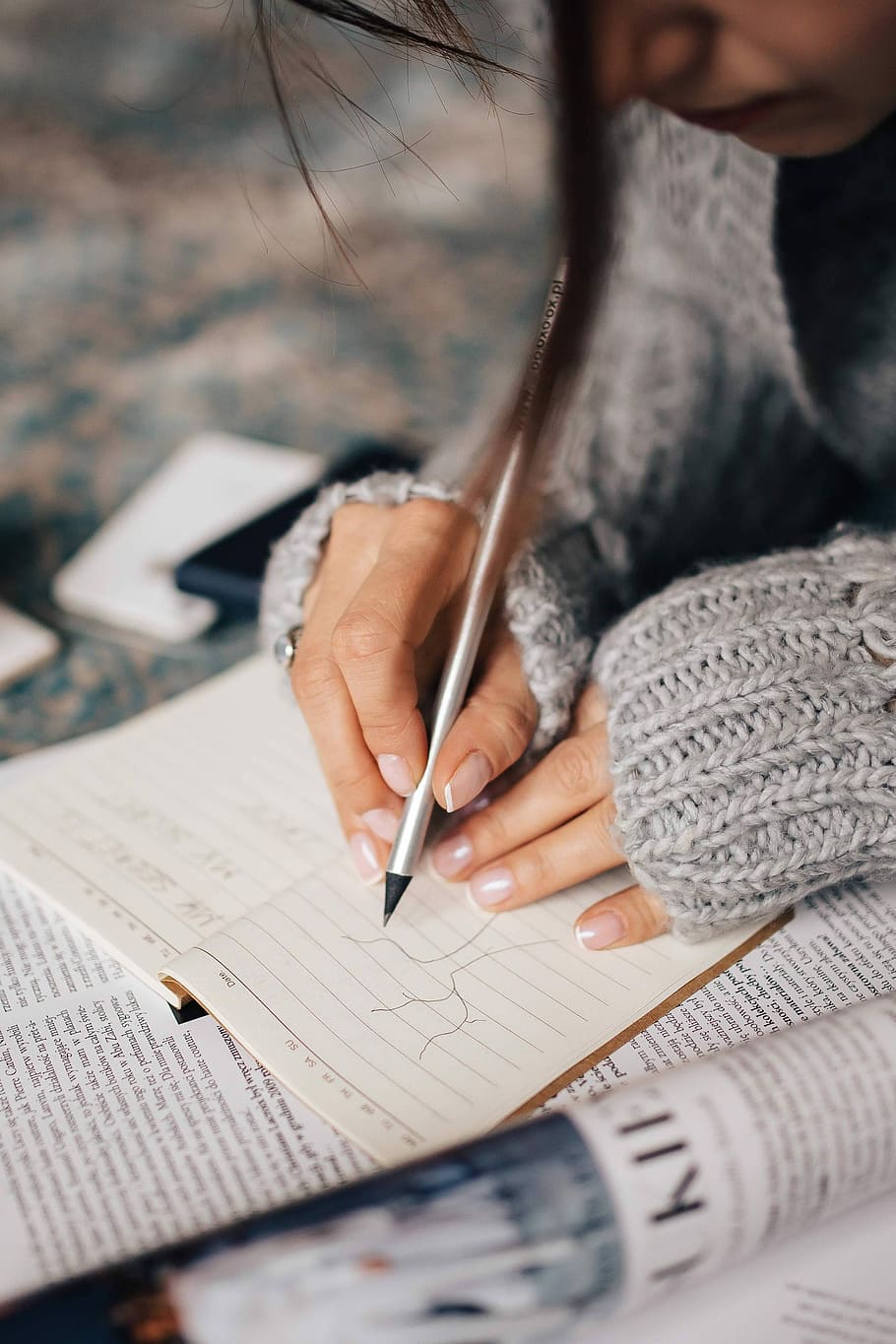 Woman in a grey sweater taking notes in an organizer, notebook HD wallpaper