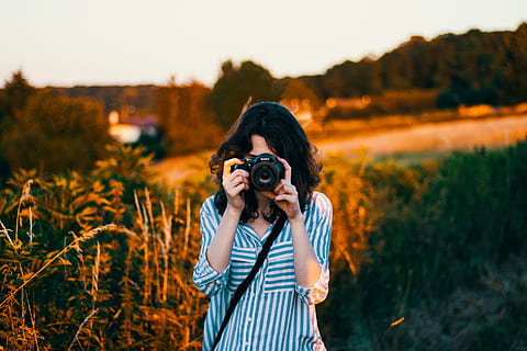 selective focus photography of woman wearing teal and white striped elbow-sleeved blouse, woman's taking pictures HD wallpaper