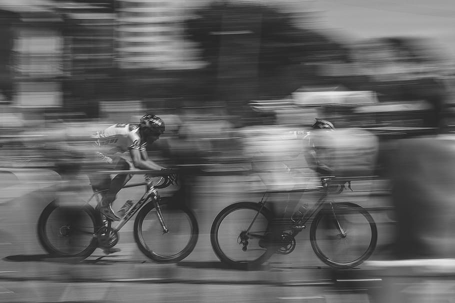 two person racing a bicycle grayscale photo, bike riding, fast moving