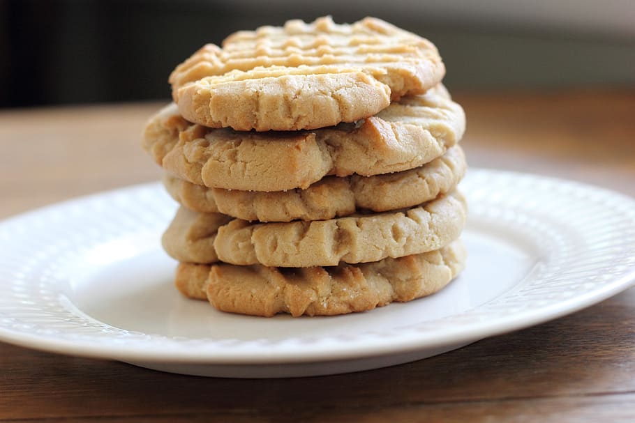 stacked five baked cookies on white ceramic plate selective focus photo HD wallpaper