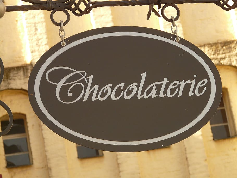 oval brown and white Cocolaterie-printed steel hanging signage HD wallpaper