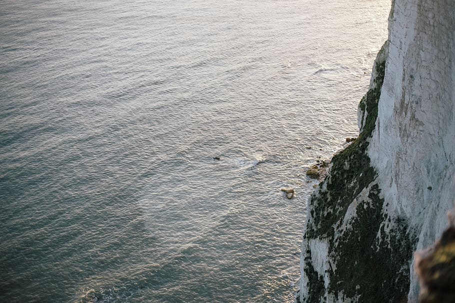 white rocky mountain next to ocean, gray cliff at daytime, sea HD wallpaper