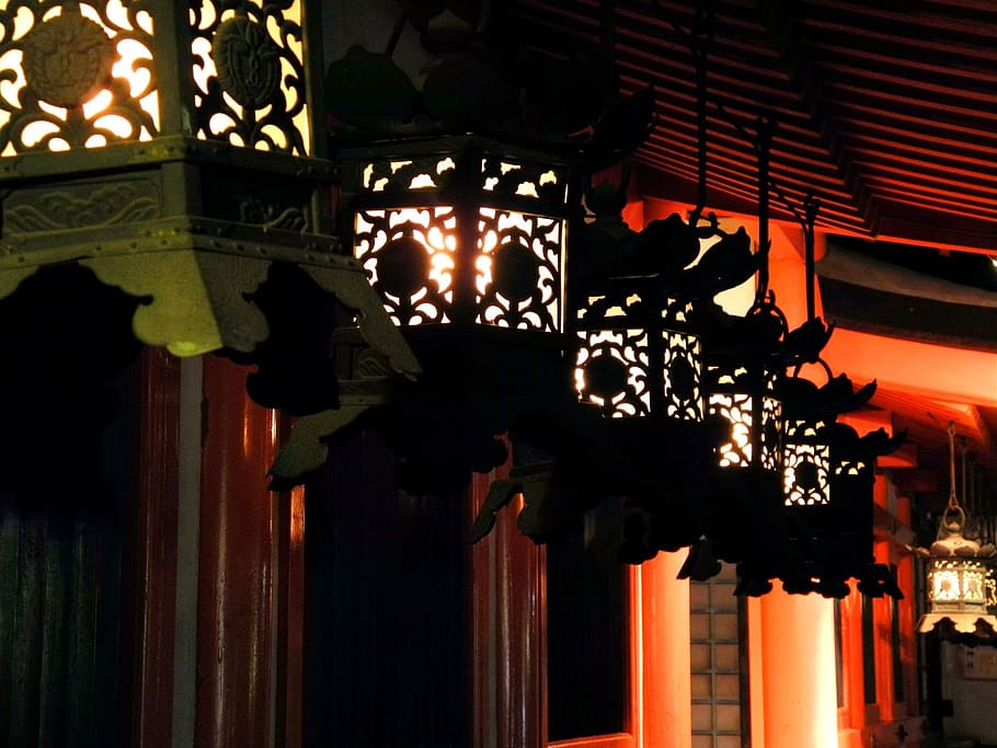 lighted black lantern lamps hanging near brown wall, kasuga shrine