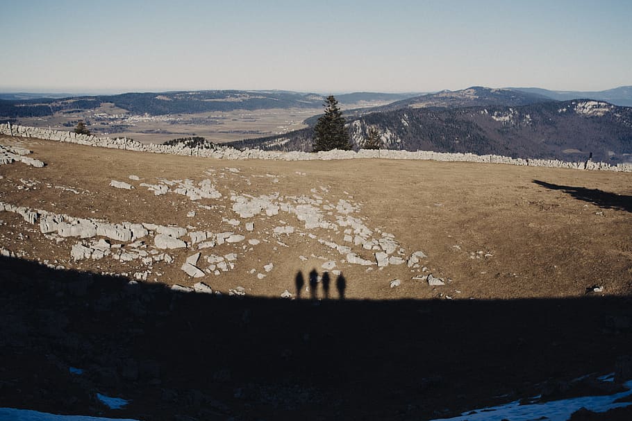 shadow of 4 people on dirt ground, silhouette of four persons on brown open field during daytime HD wallpaper