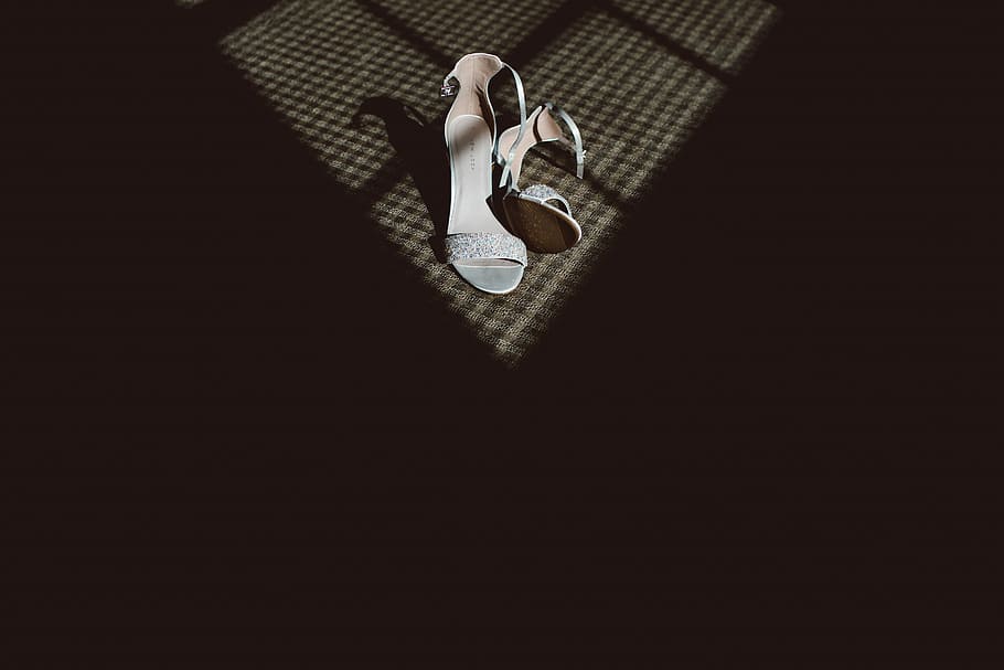 pair of white heels against black shadow, pair of white ankle-strap sandals on brown surface HD wallpaper