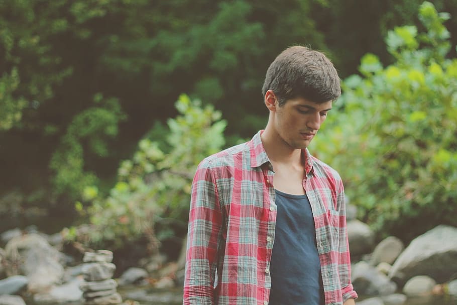 man wearing plaid button-up sports shirt looking down during daytime HD wallpaper